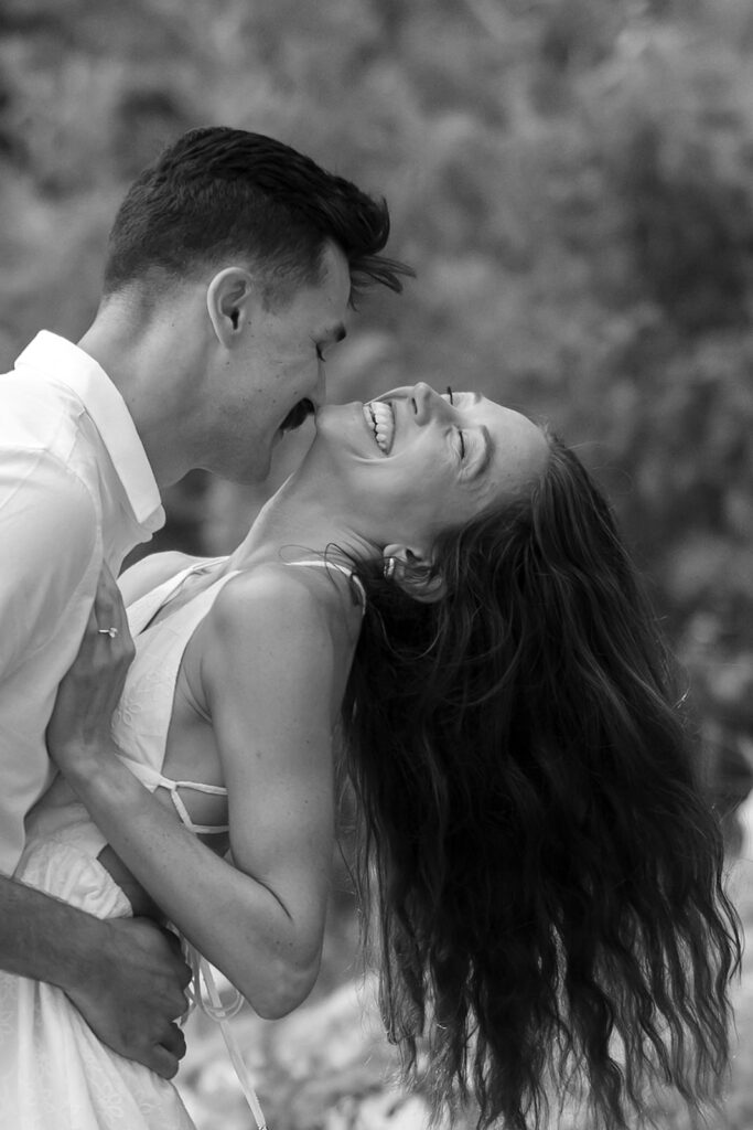 playful couple in a forest during their minnesota engagement session