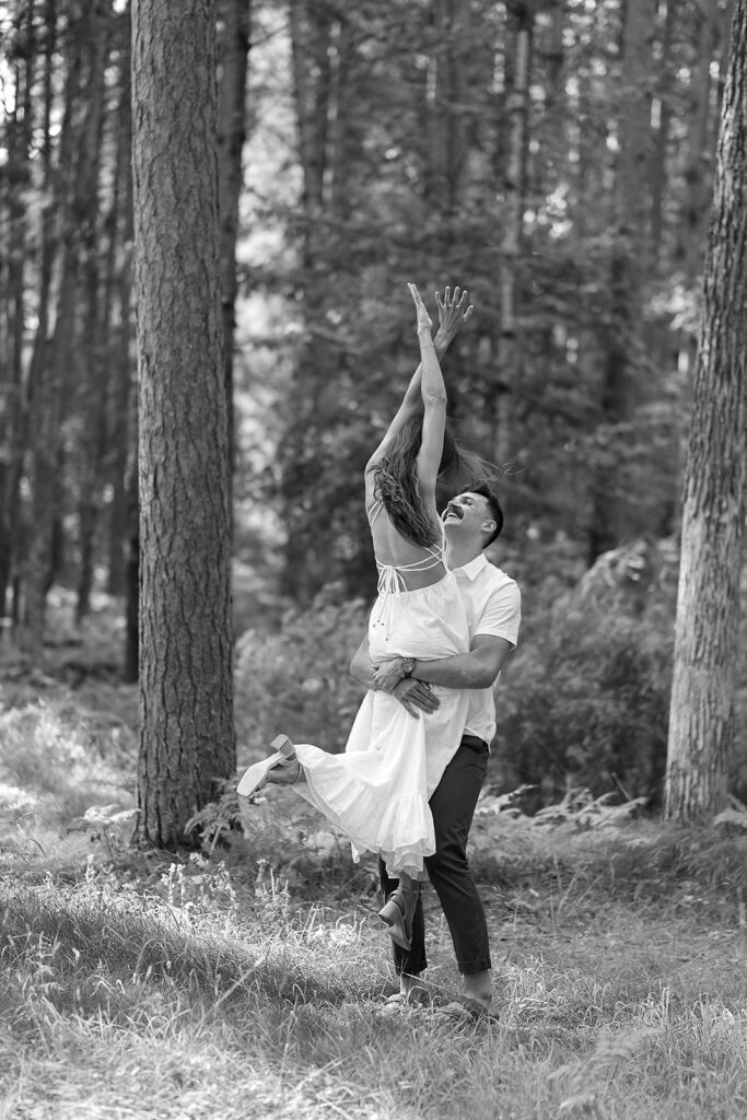 playful couple in a forest during their minnesota engagement session
