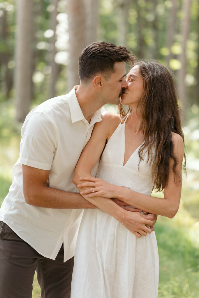 playful couple in a forest during their minnesota engagement session