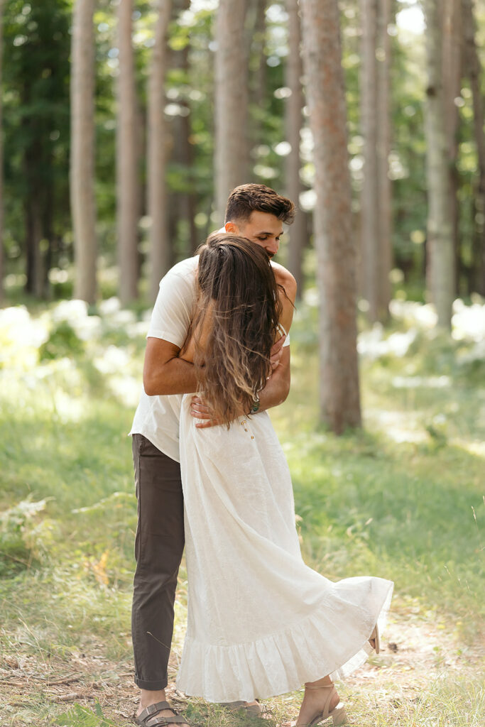 playful couple in a forest during their minnesota engagement session