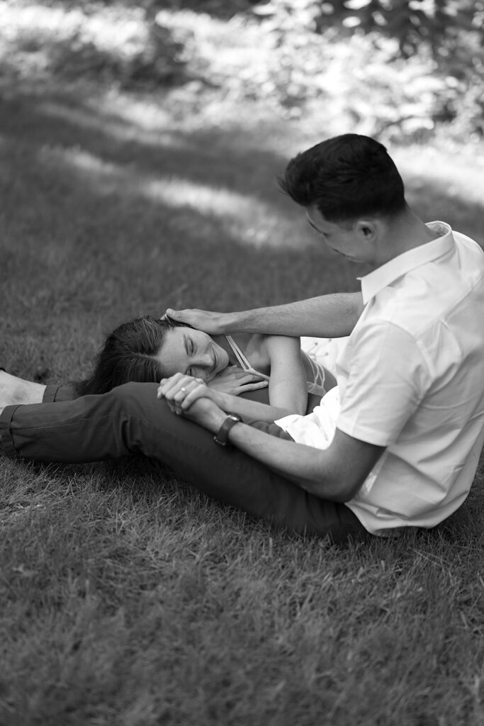 sweet couple sitting in the grass together surrounded by forest