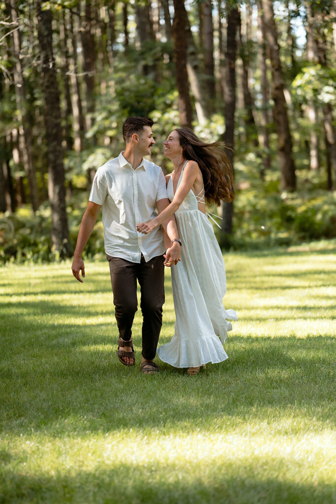 playful couple in a forest during their minnesota engagement session