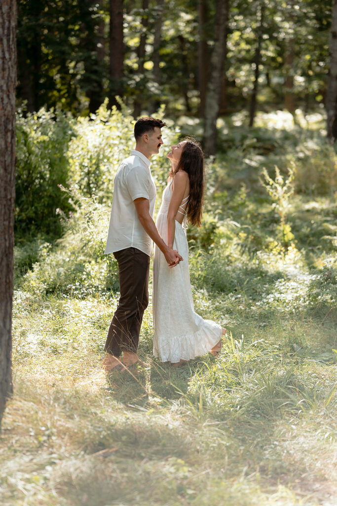 playful couple in a forest during their minnesota engagement session