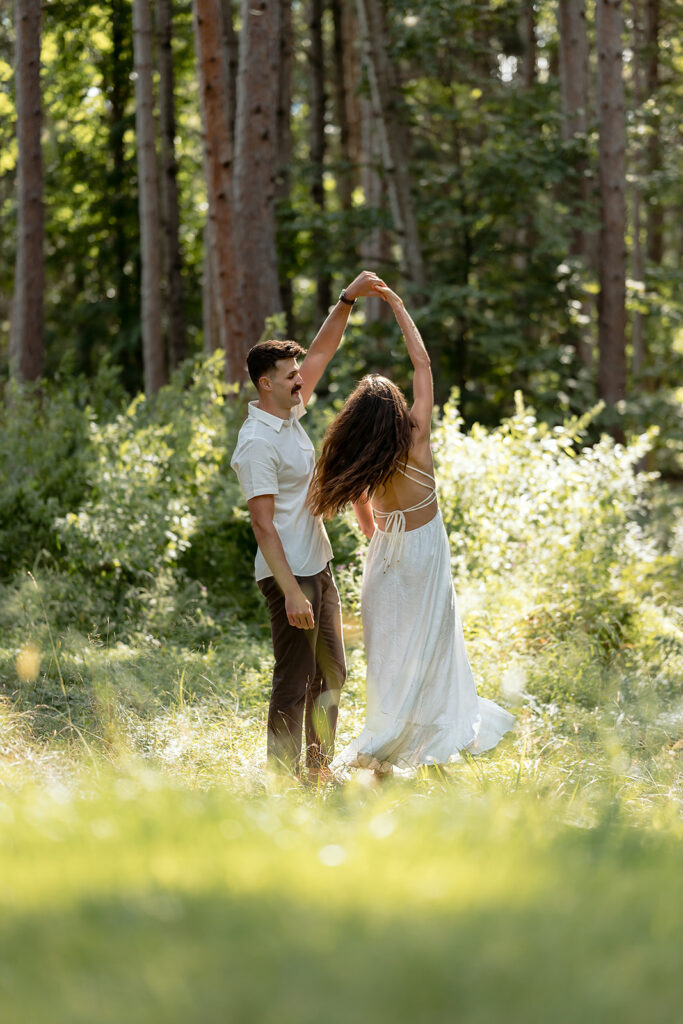 playful couple in a forest during their minnesota engagement session