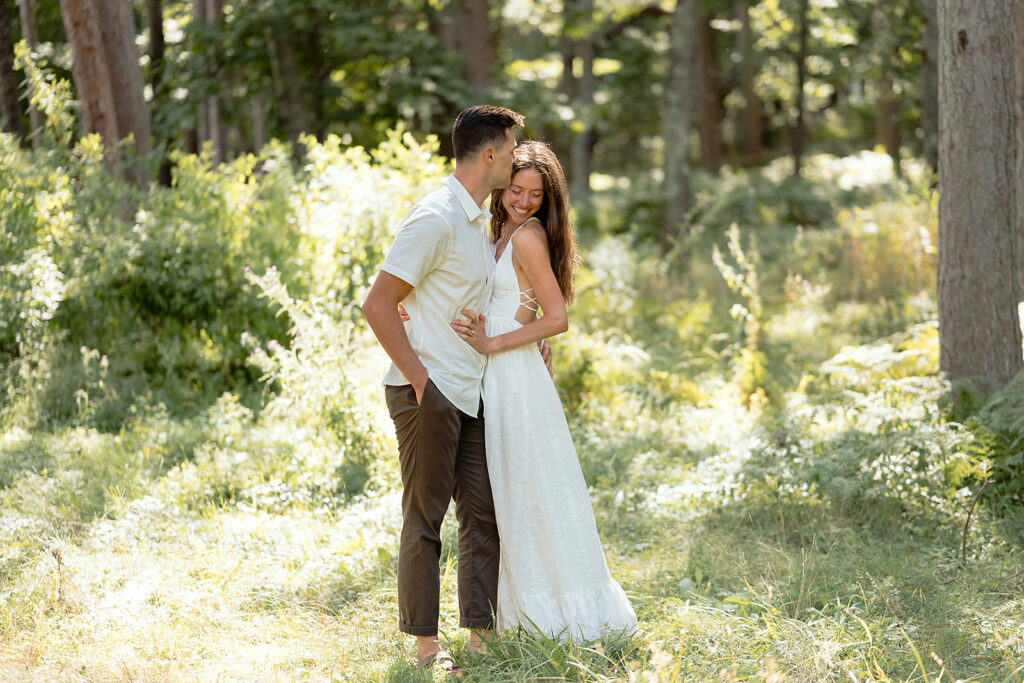 playful couple in a forest during their minnesota engagement session