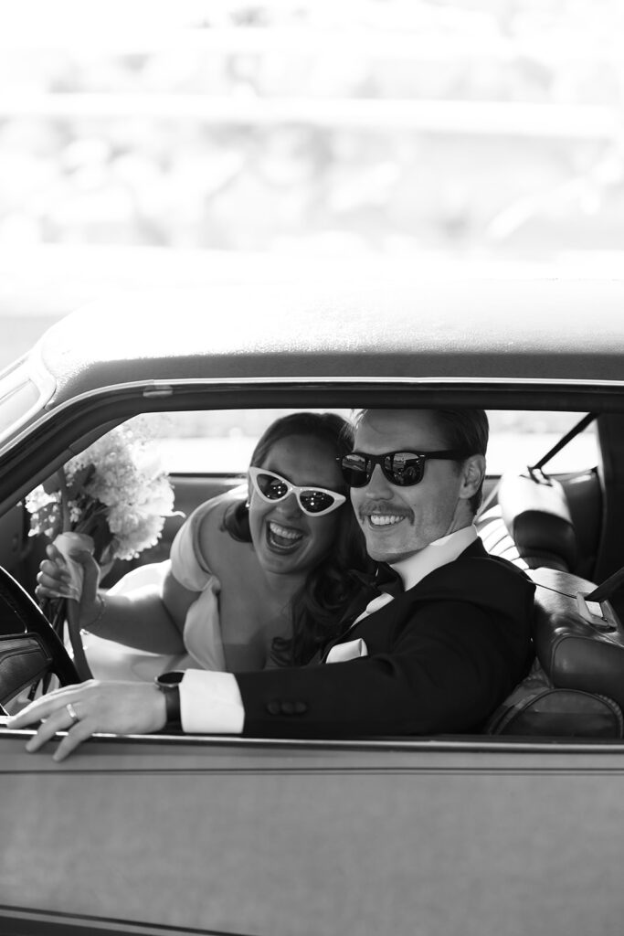 bride and groom driving off into a vintage blue chevy getaway car