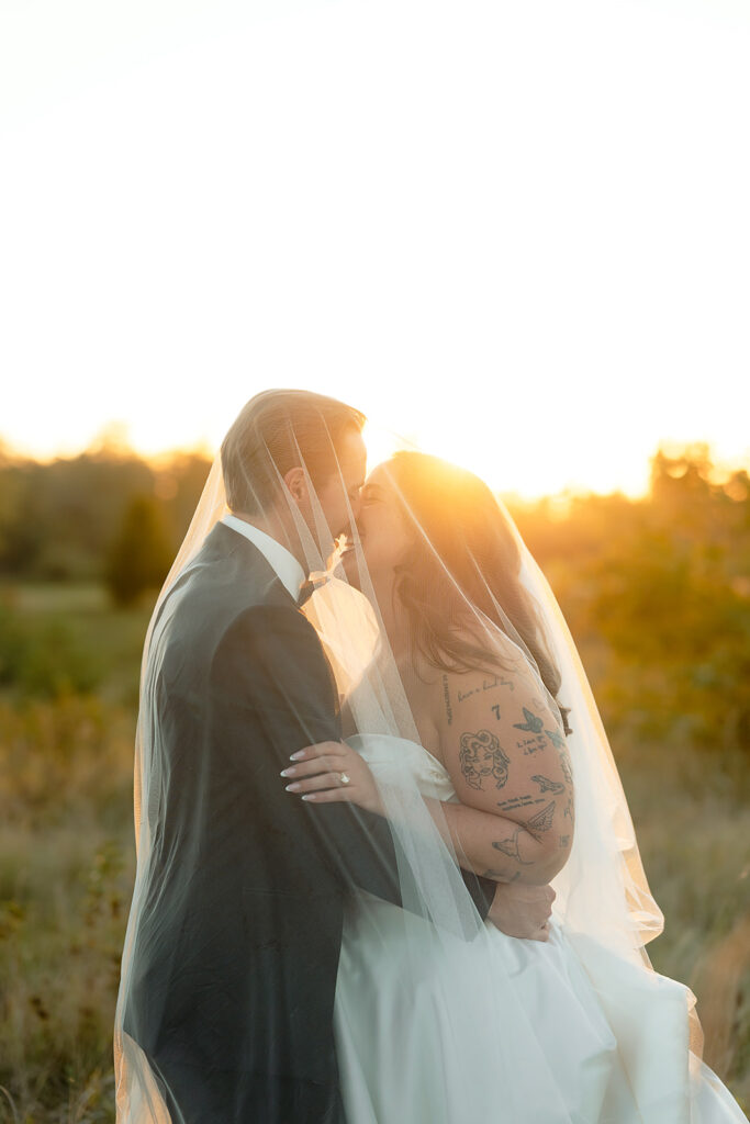 playful golden hour wedding portraits in a lush field