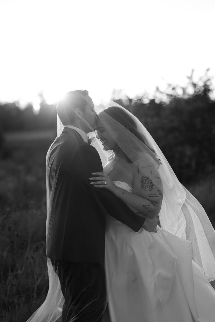 playful golden hour wedding portraits in a lush field