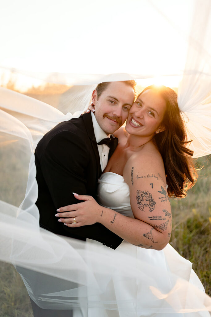 playful golden hour wedding portraits in a lush field