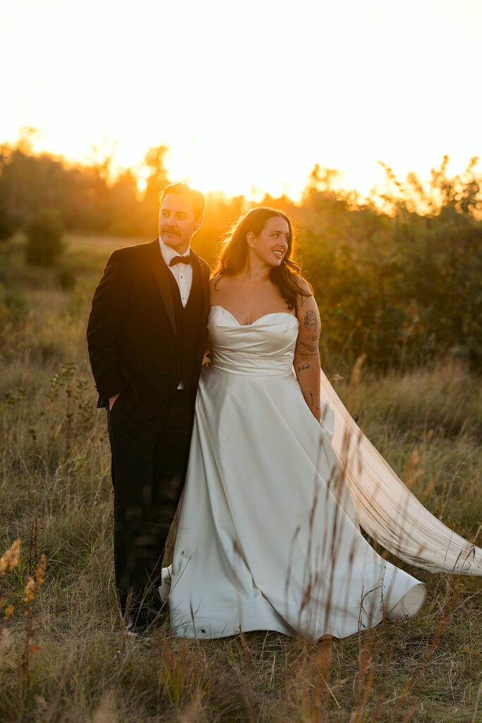 playful golden hour wedding portraits in a lush field
