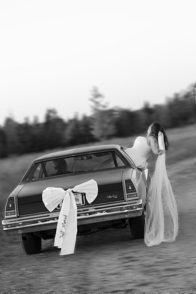 bride and groom driving off into a vintage blue chevy getaway car