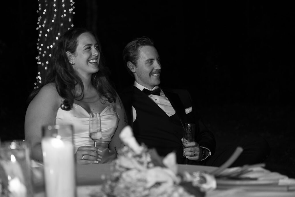 bride and groom listening to toasts during their backyard wedding reception