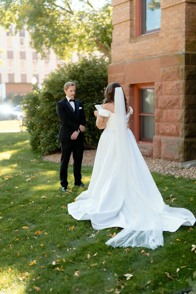 first look and private vow exchange in front of Beltrami County Courthouse during their Minnesota courthouse wedding