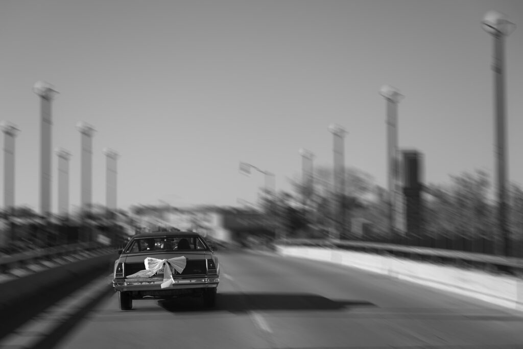 bride and groom driving off into a vintage blue chevy getaway car