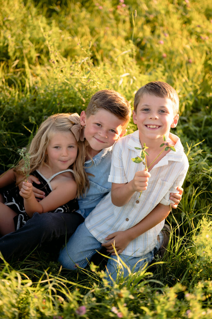 three kids happy in a lush field