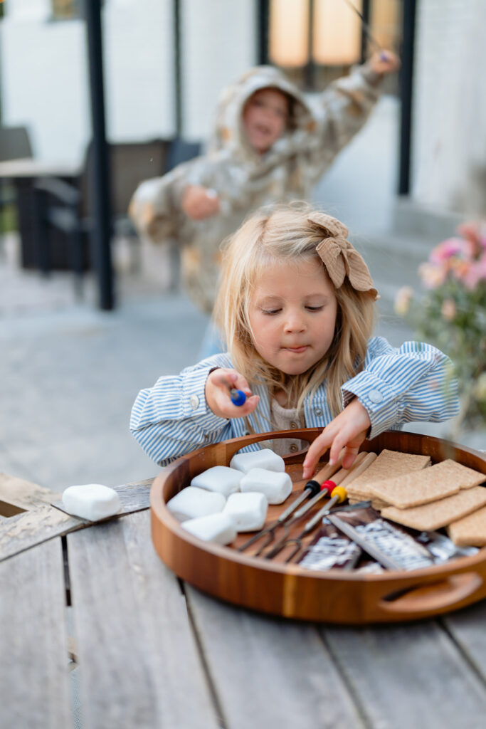 family making s'mores in their backyard