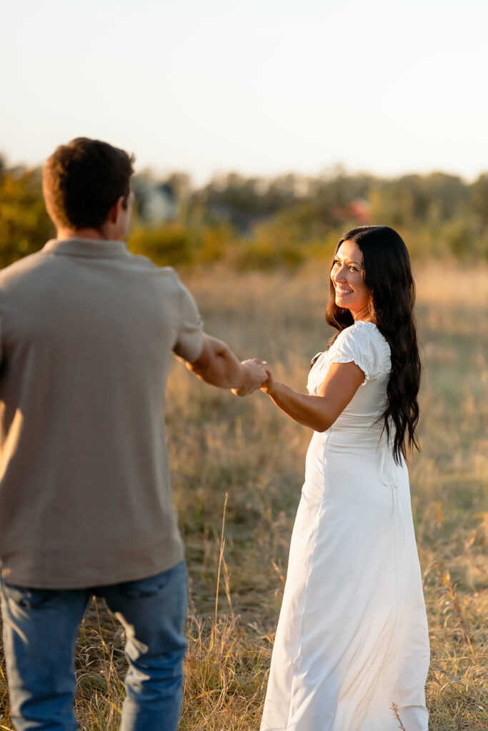 playful and romantic engagement photos in a golden field in bemidji mn