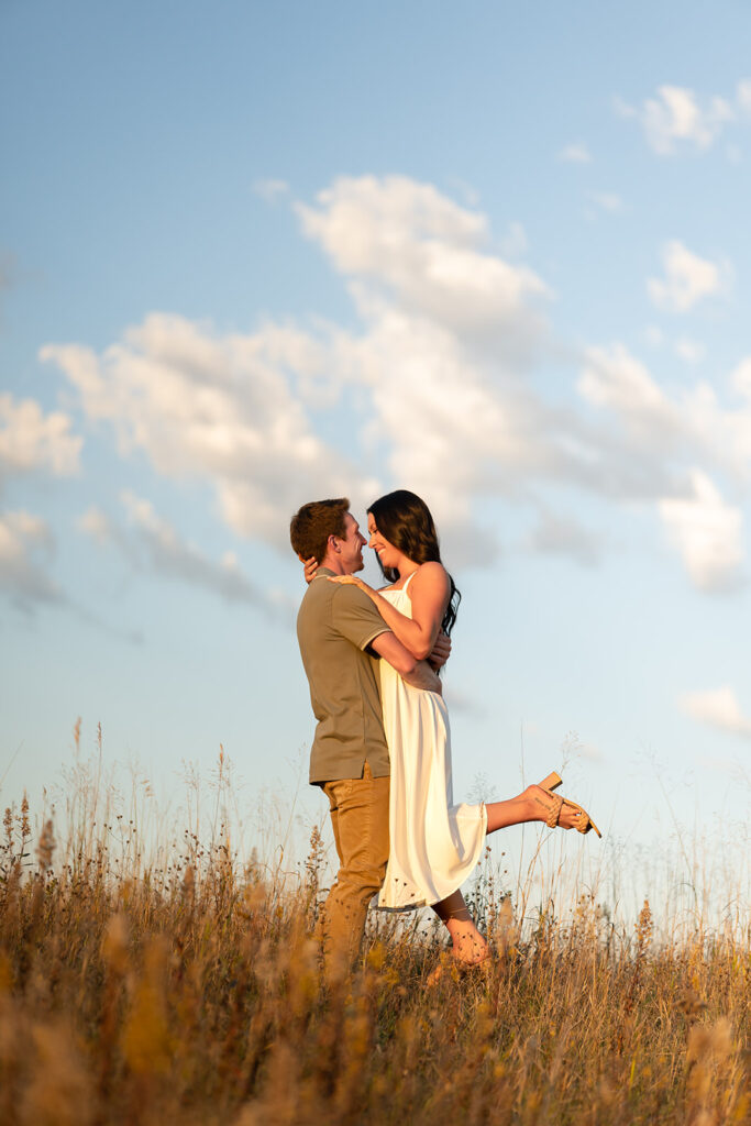 playful and romantic engagement photos in a golden field in bemidji mn