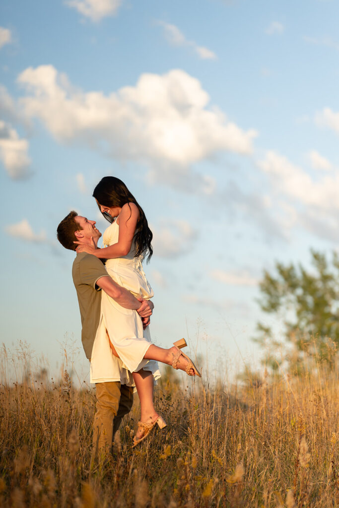 playful and romantic engagement photos in a golden field in bemidji mn