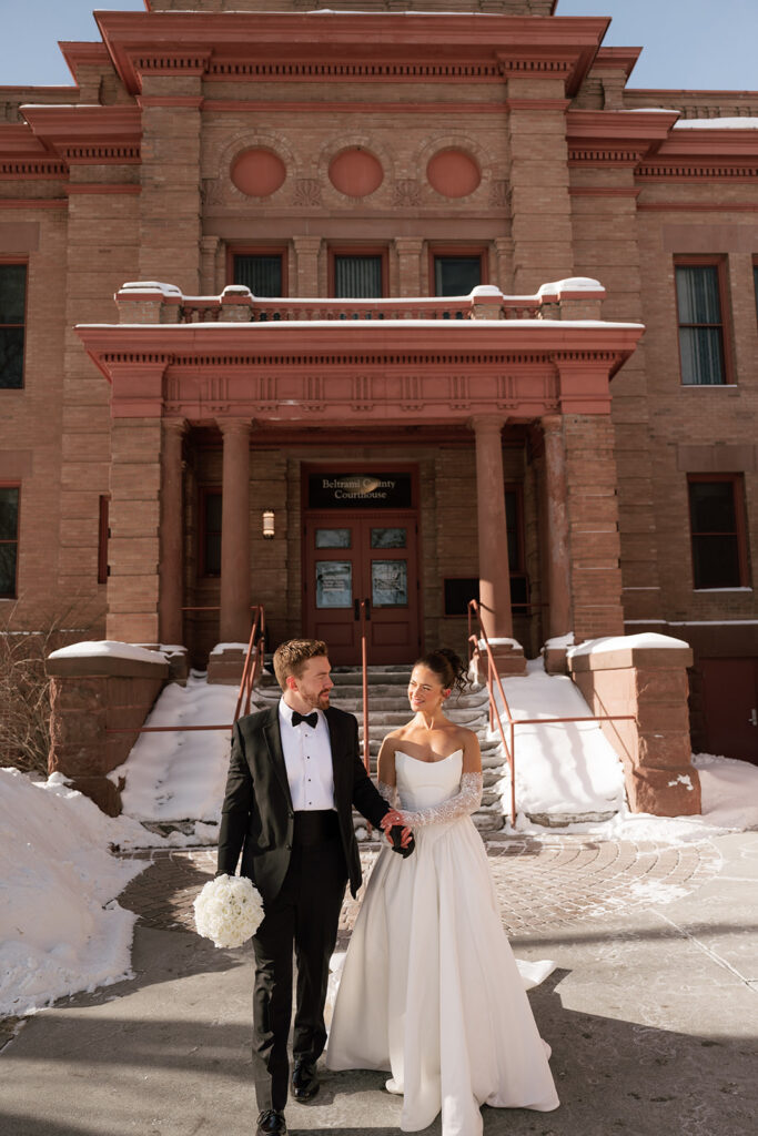 cheerful bride and groom in front of the Beltrami County Courthouse