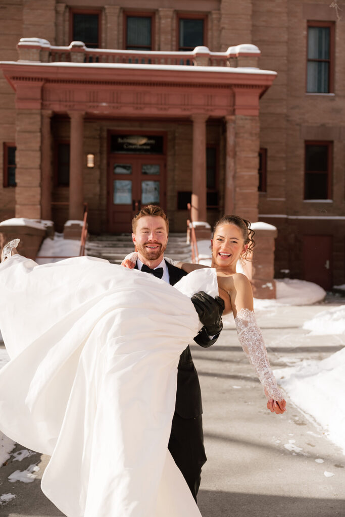 cheerful bride and groom in front of the Beltrami County Courthouse