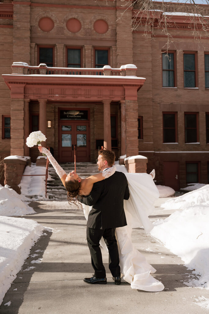 cheerful bride and groom in front of the Beltrami County Courthouse