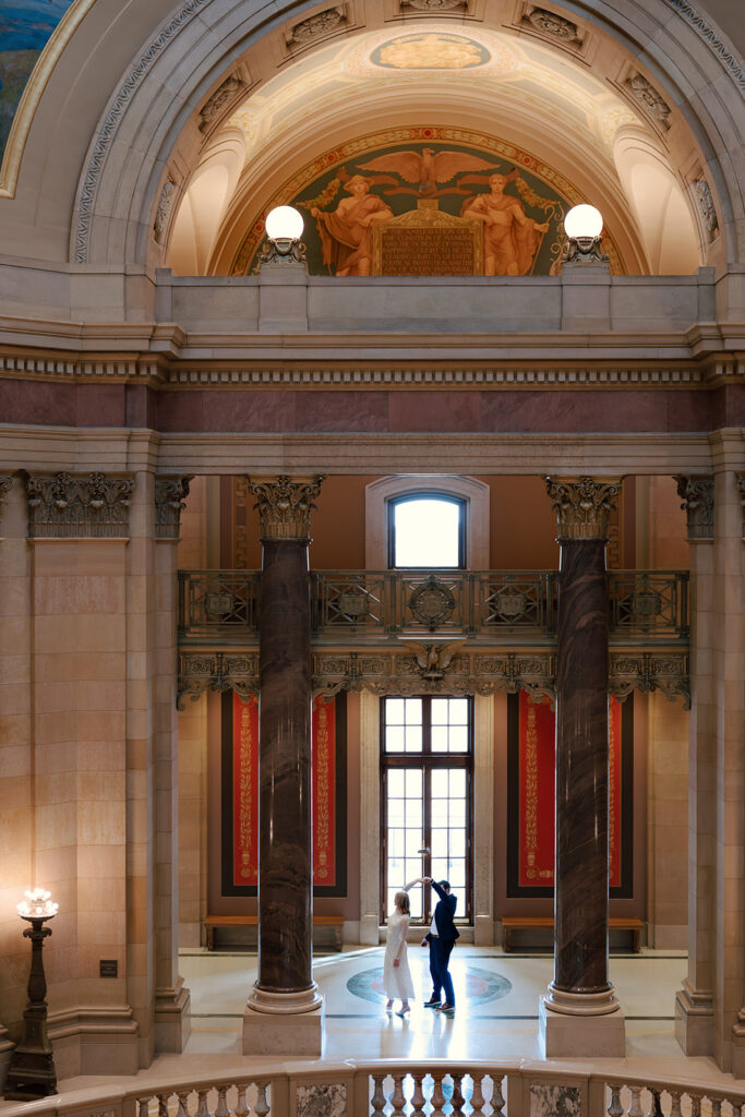 engagement portraits framed by marble columns inside the Minnesota State Capitol