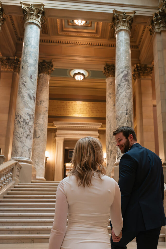 candid engagement photos on the grand staircase inside the Minnesota State Capitol