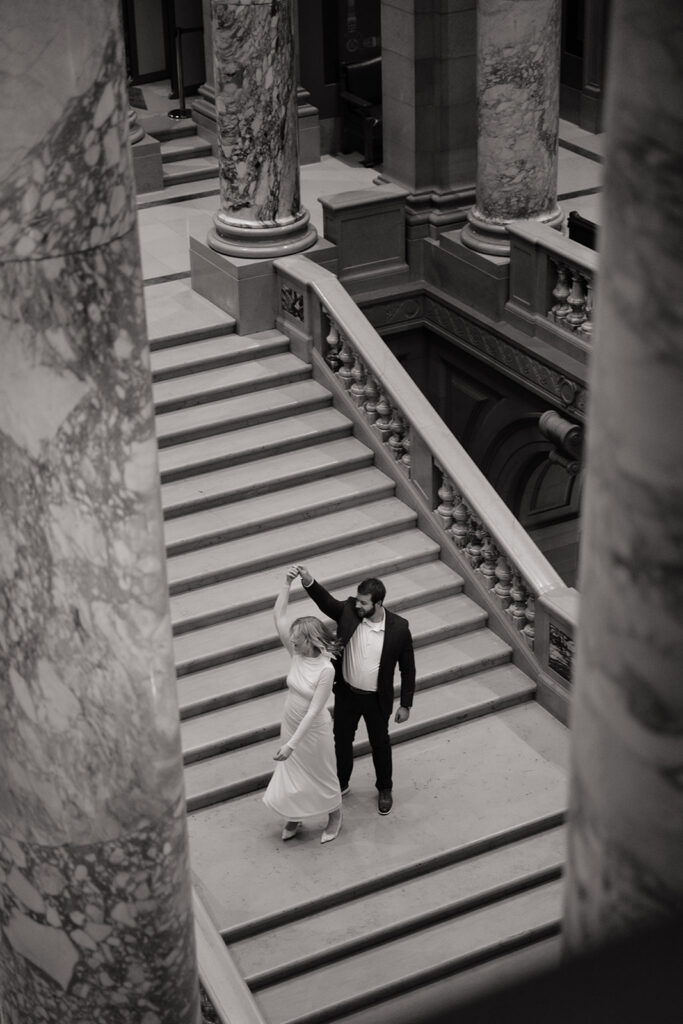 engaged couple cuddling on stairs during Minnesota State Capitol photo session