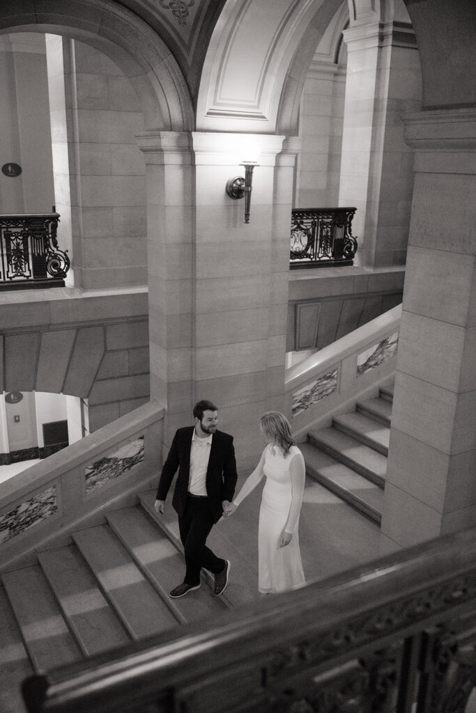 engaged couple cuddling on stairs during Minnesota State Capitol photo session