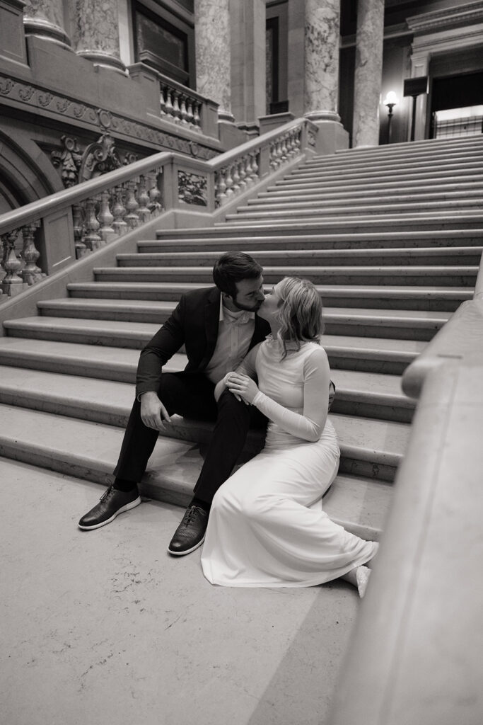 couple sitting on marble staircase during Minnesota State Capitol engagement photos