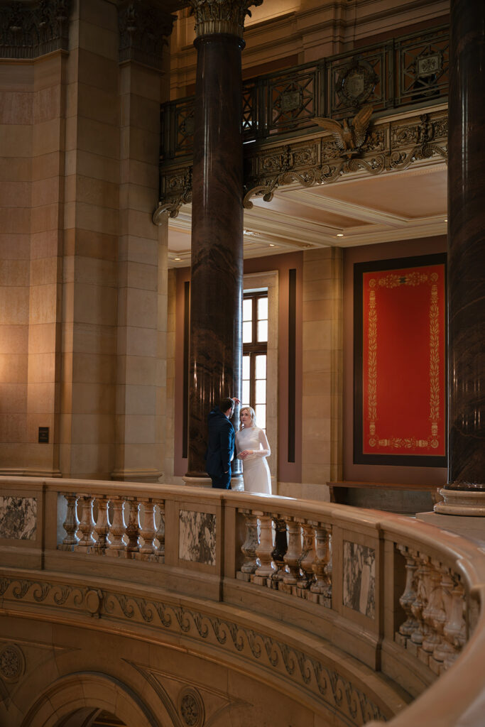 engagement portraits framed by marble columns inside the Minnesota State Capitol