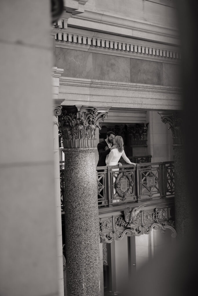 engaged couple posing in elegant marble hallway at the Minnesota State Capitol