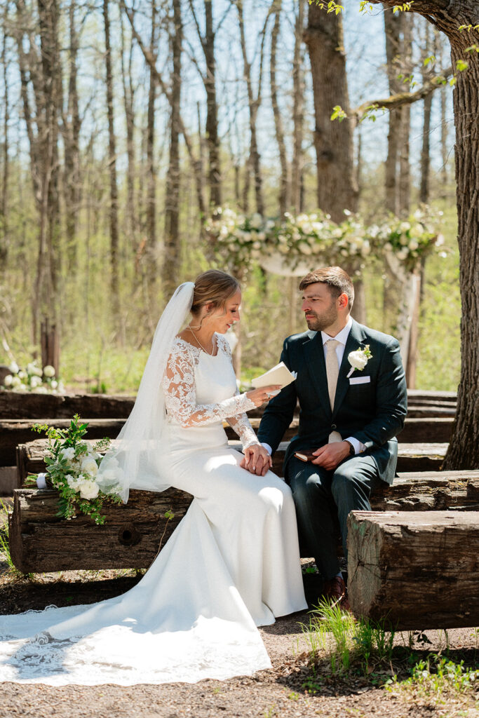 bride and groom sitting at the outdoor ceremony space of The Atrium in Solon Springs, Wisconsin