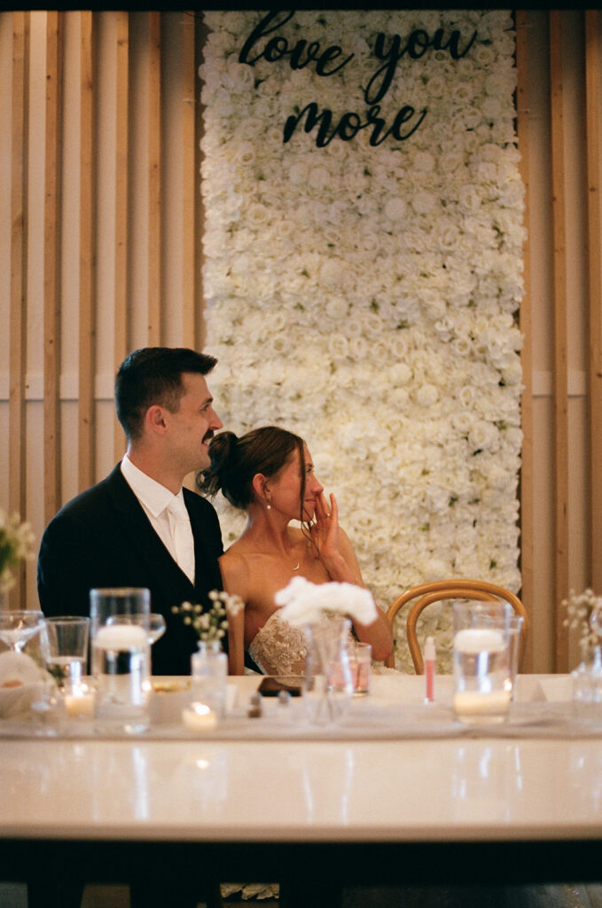 candid bride and groom reactions during wedding speeches