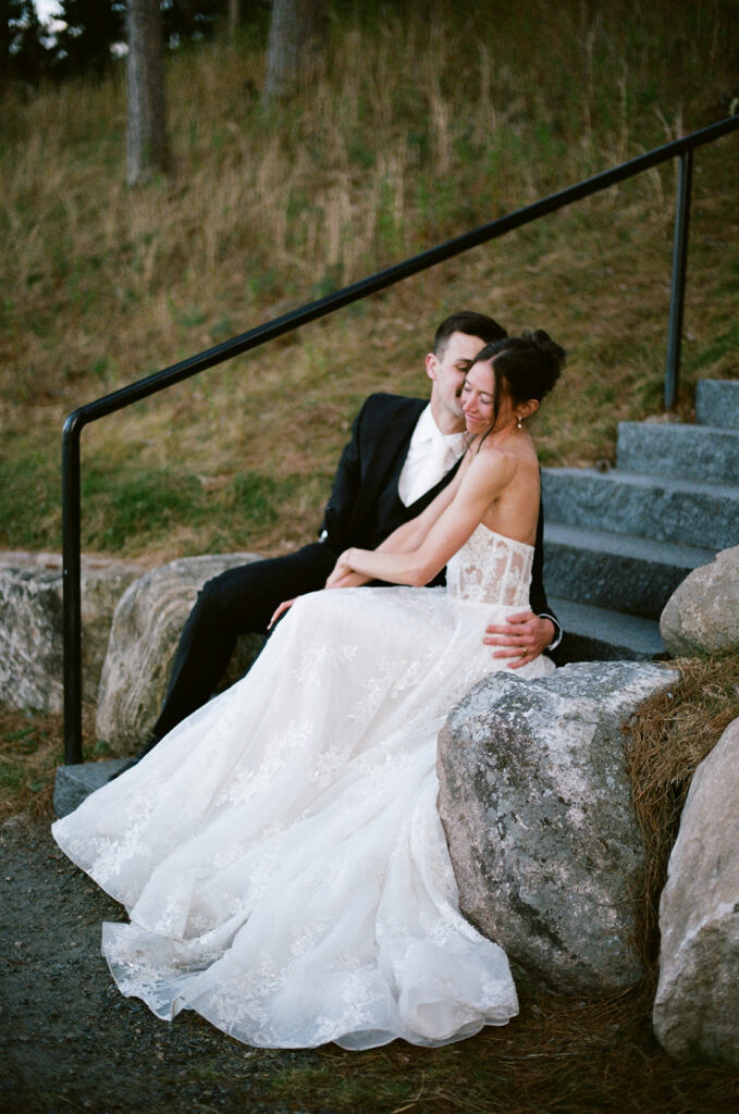 bride and groom sitting on the steps at the catalyst by nature link