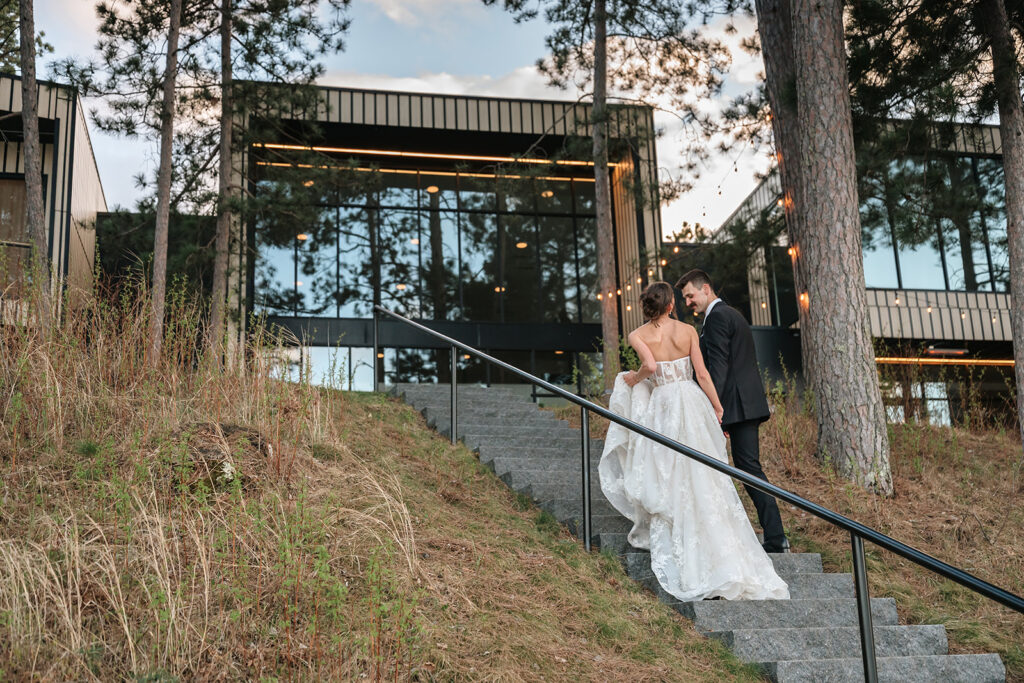 bride and groom walking up the steps at the catalyst by nature link