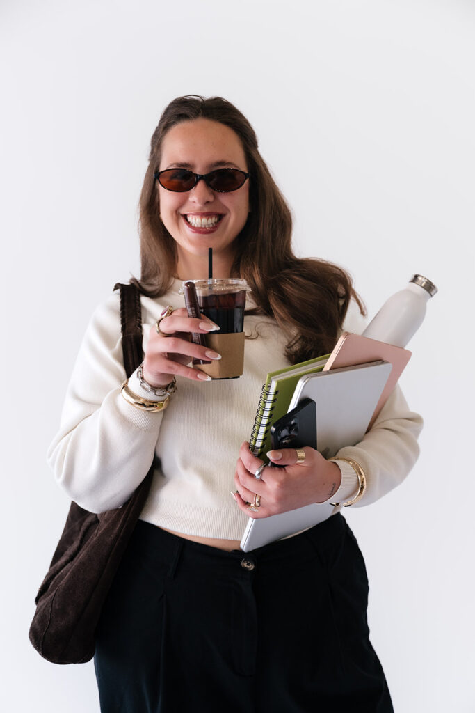 Smiling creative entrepreneur posing with coffee during her studio brand photography session.