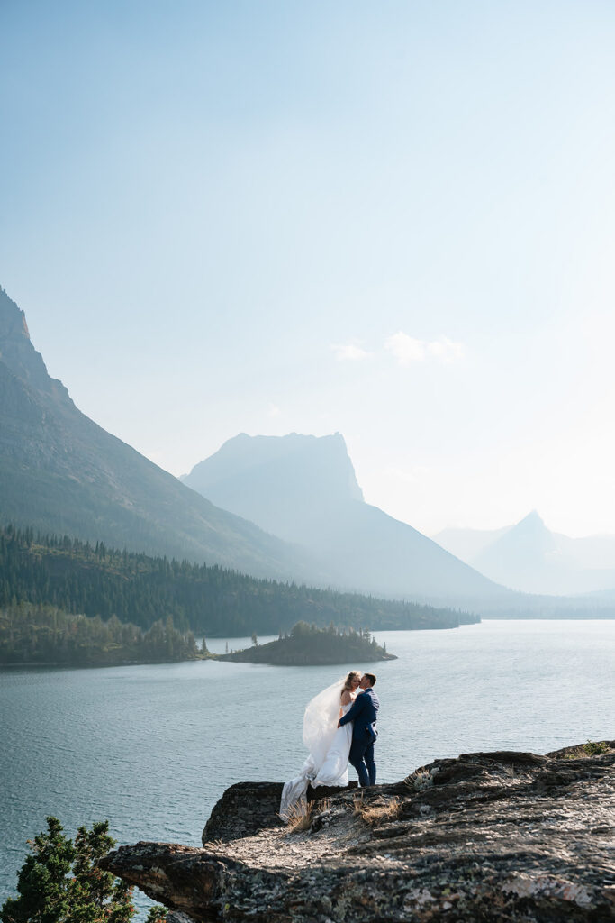 bride and groom kissing at a mountain overlook during glacier national park elopement