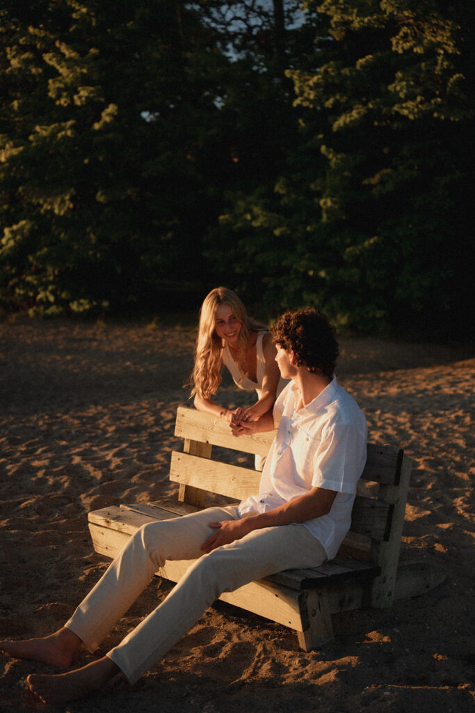 playful couple at the beach of lake bemidji during sunset