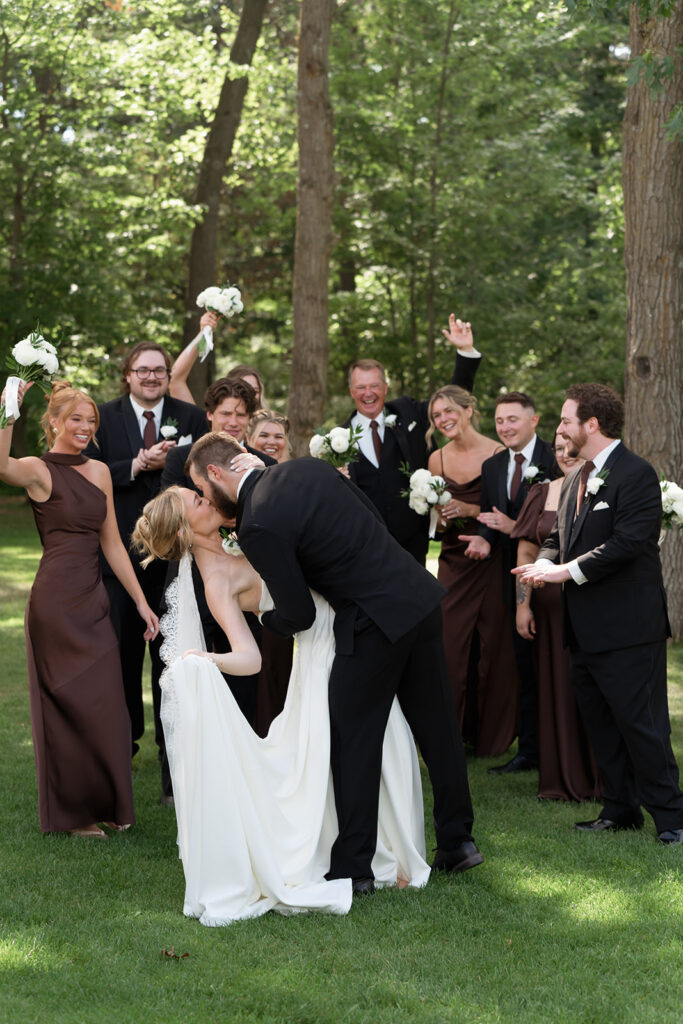 wedding couple kissing surrounded by bridal party